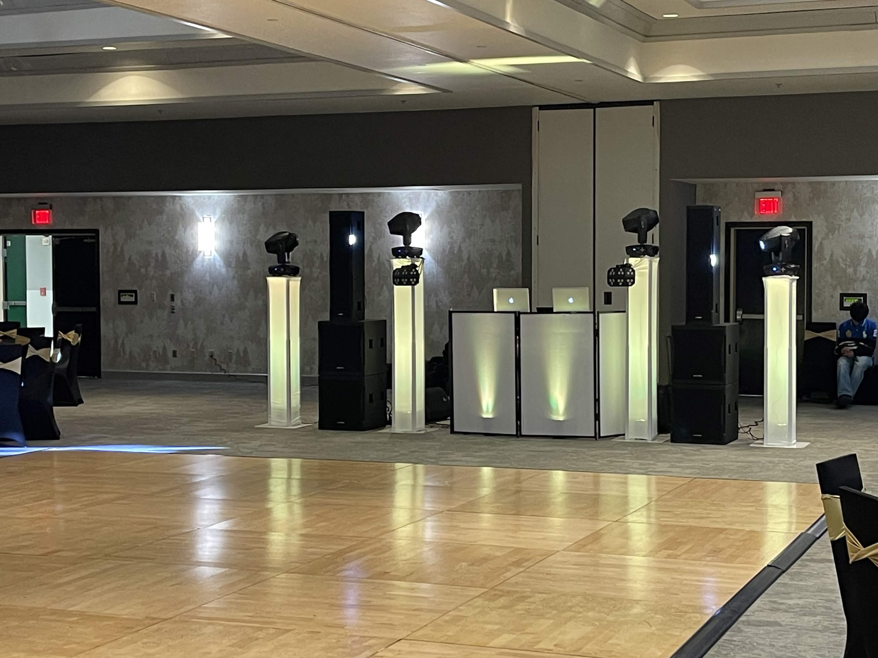 Ballroom DJ booth with ivory lighting columns and full speaker system