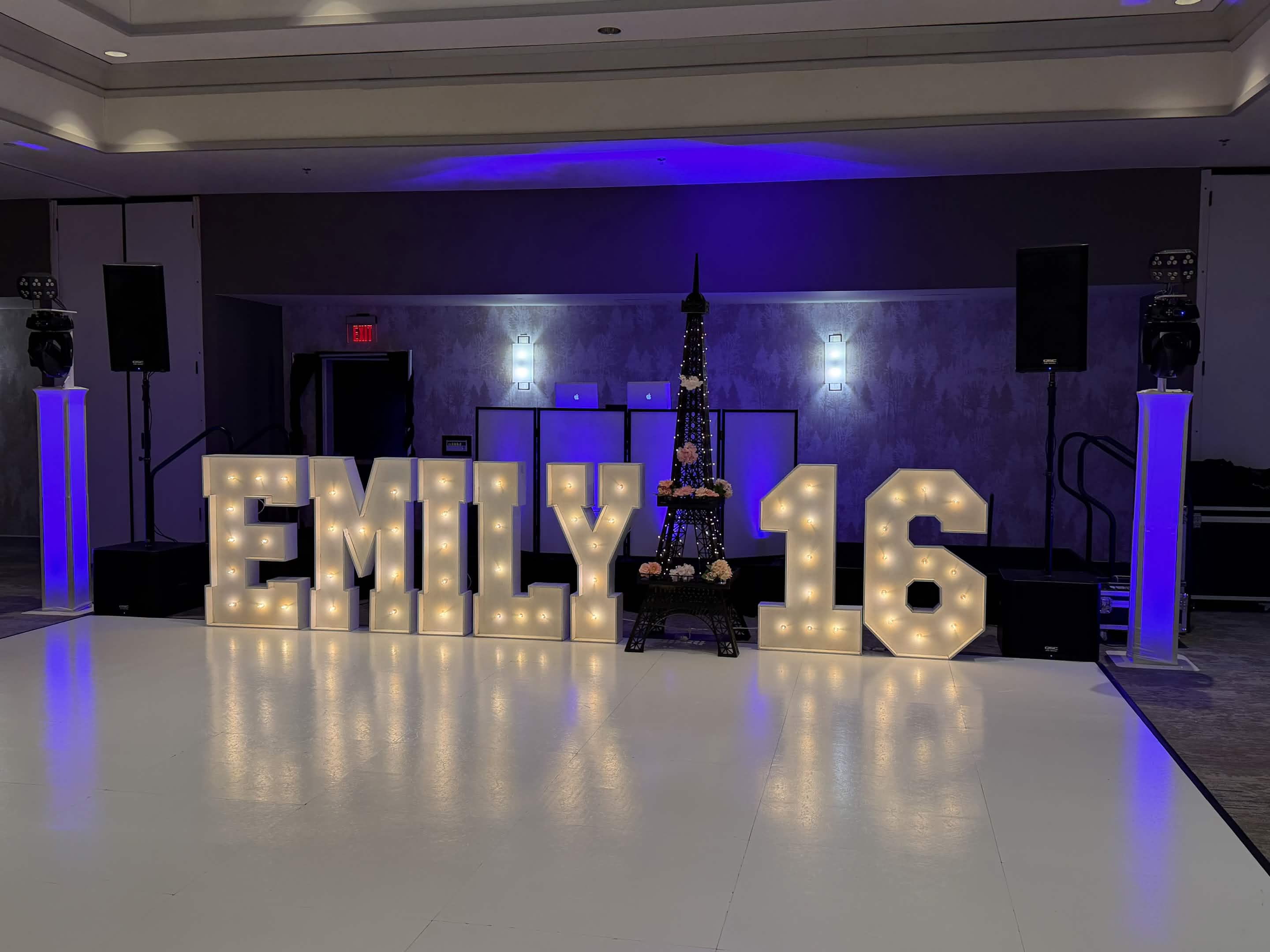 Sweet sixteen DJ setup with illuminated marquee letters and blue lighting
